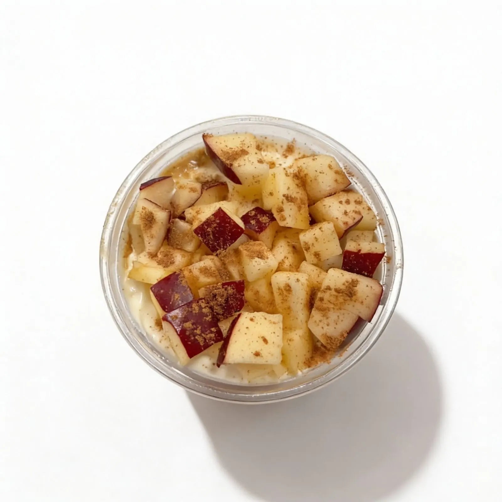 Container of oatmeal with apples and cinnamon on a white background