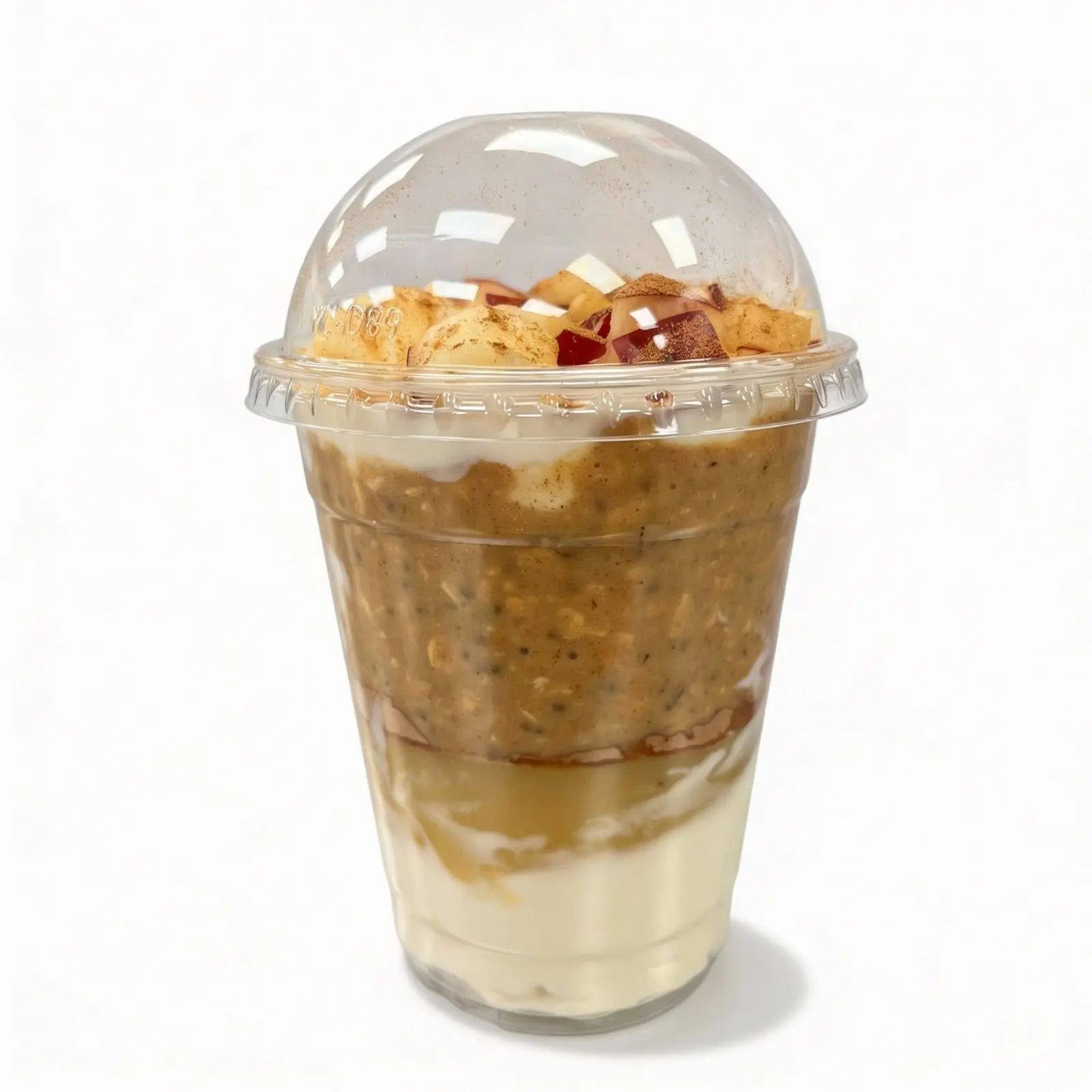 Clear plastic container with layered dessert on a white background