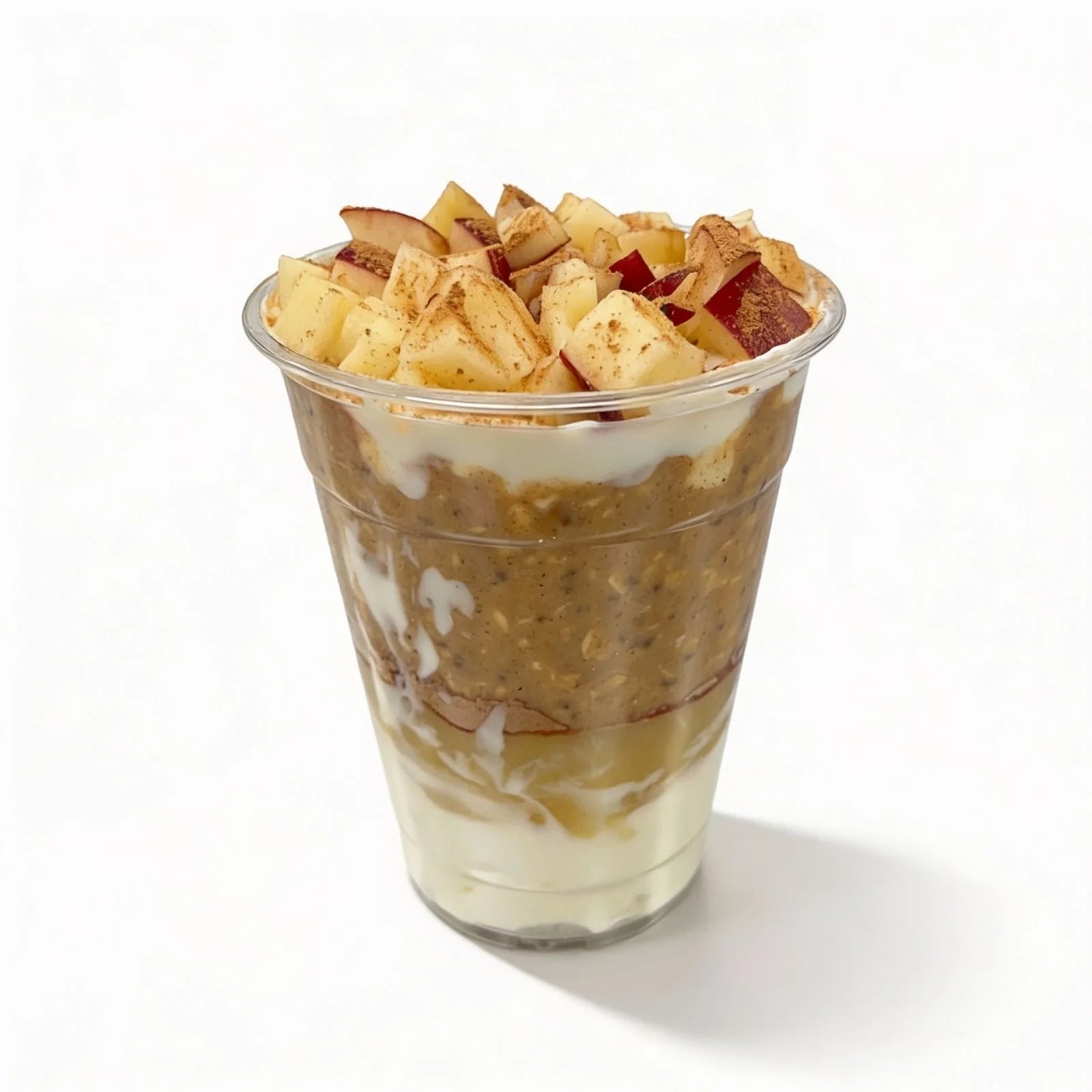Dessert in a clear plastic cup with layers of cream and fruit on a white background