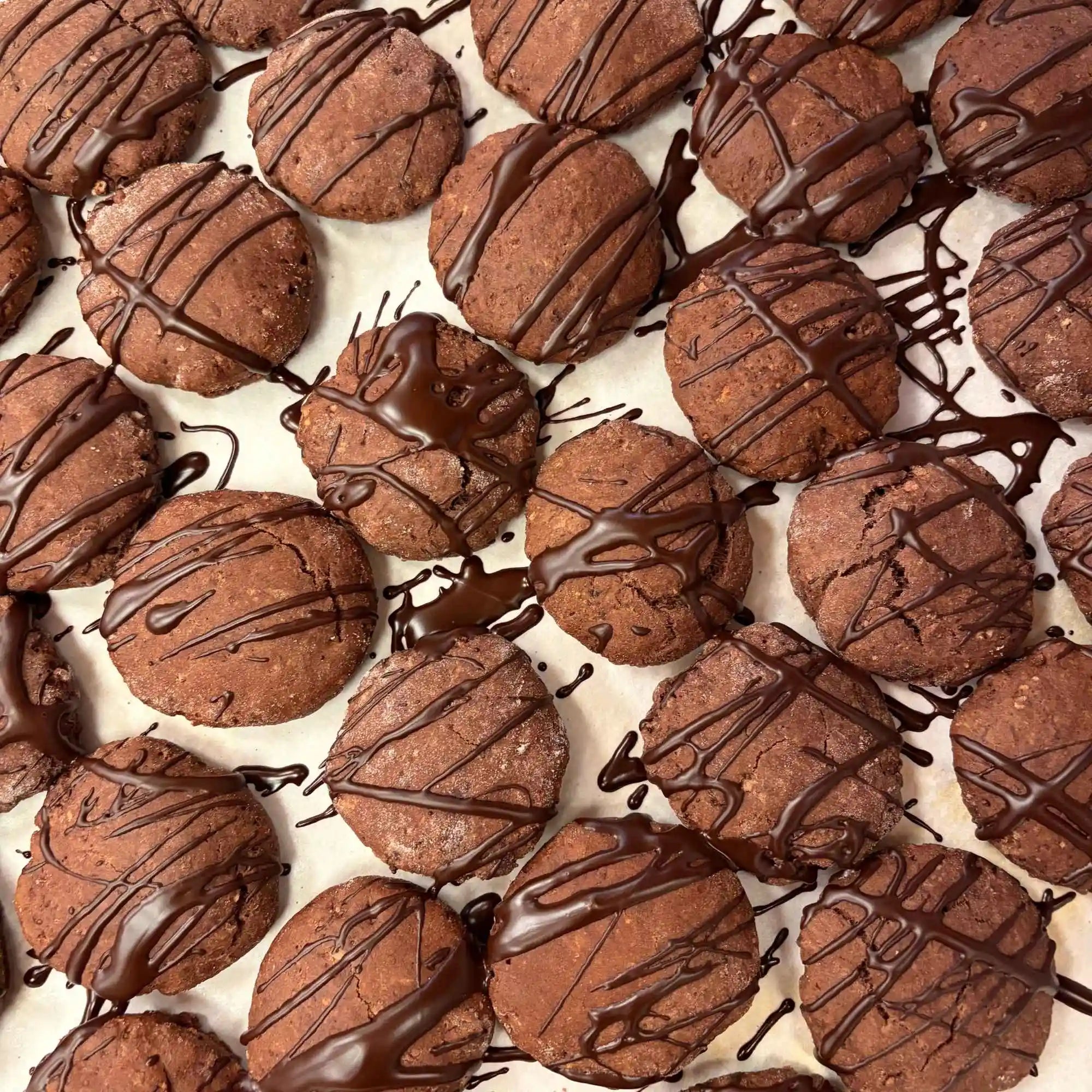 Large batch of chocolate cookies with dark chocolate drizzle for office and event orders in Edmonton.