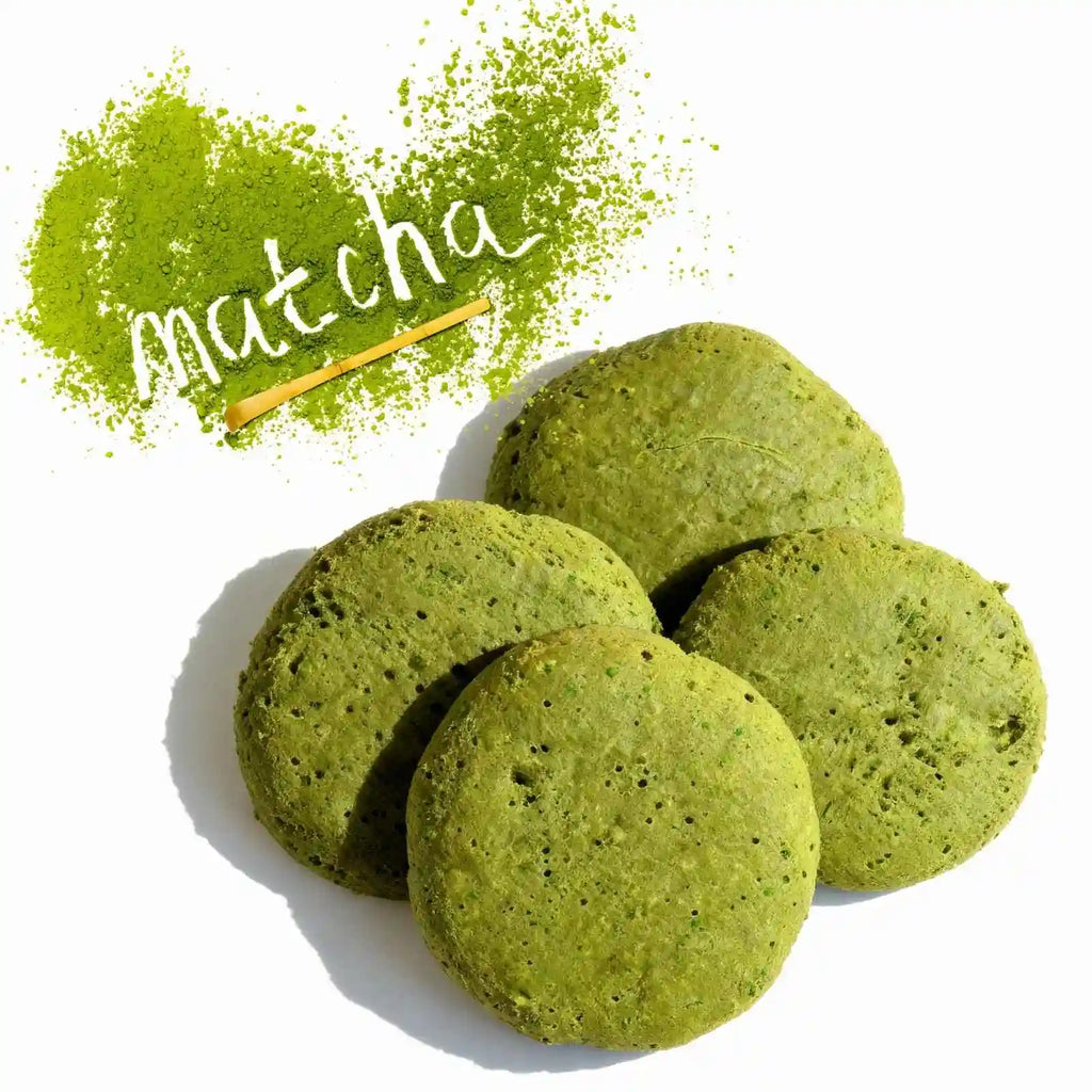 Hight protein organic matcha green tea cookies with matcha powder and a wooden spoon on a white background.