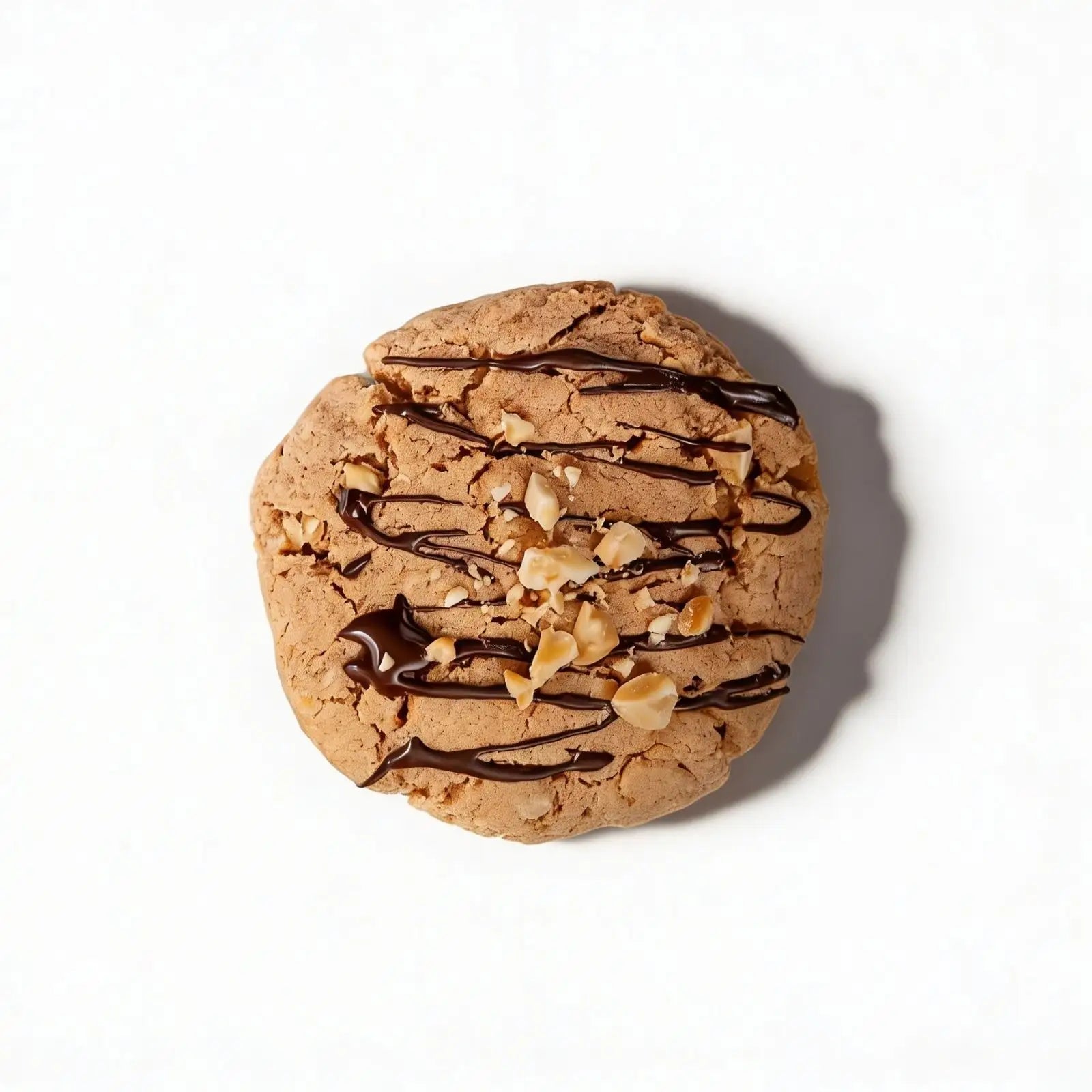 Protein cookie with chocolate drizzle and nuts on a white background