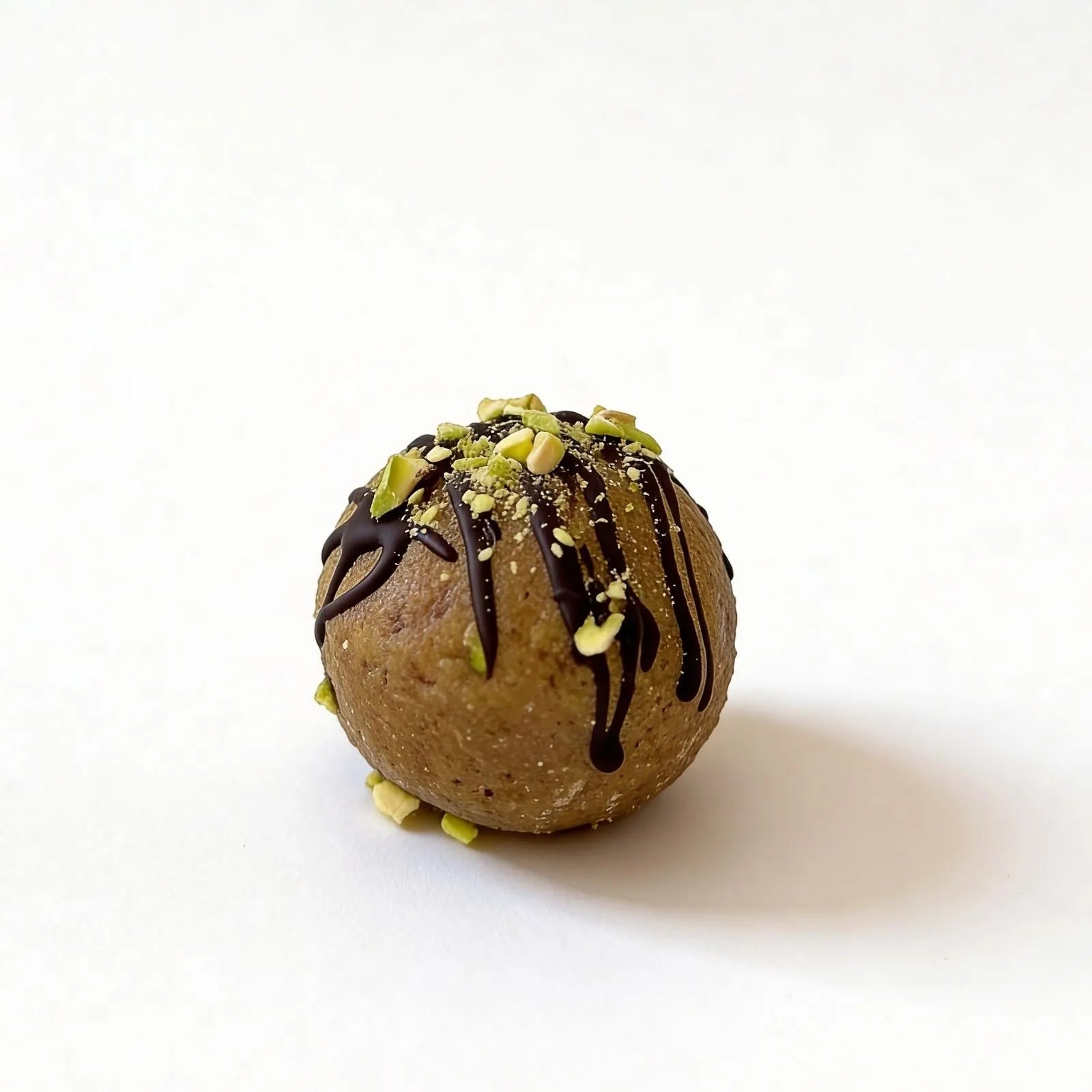 Energy balls protein chocolate-dipped cookie ball with pistachios on a white background.