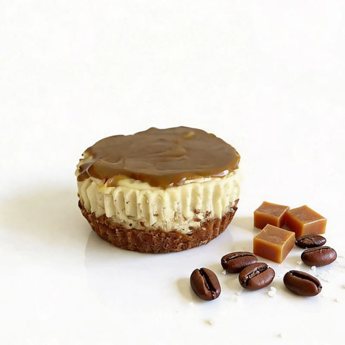 Mini cheesecake with caramel topping, coffee beans, and caramels on a white background